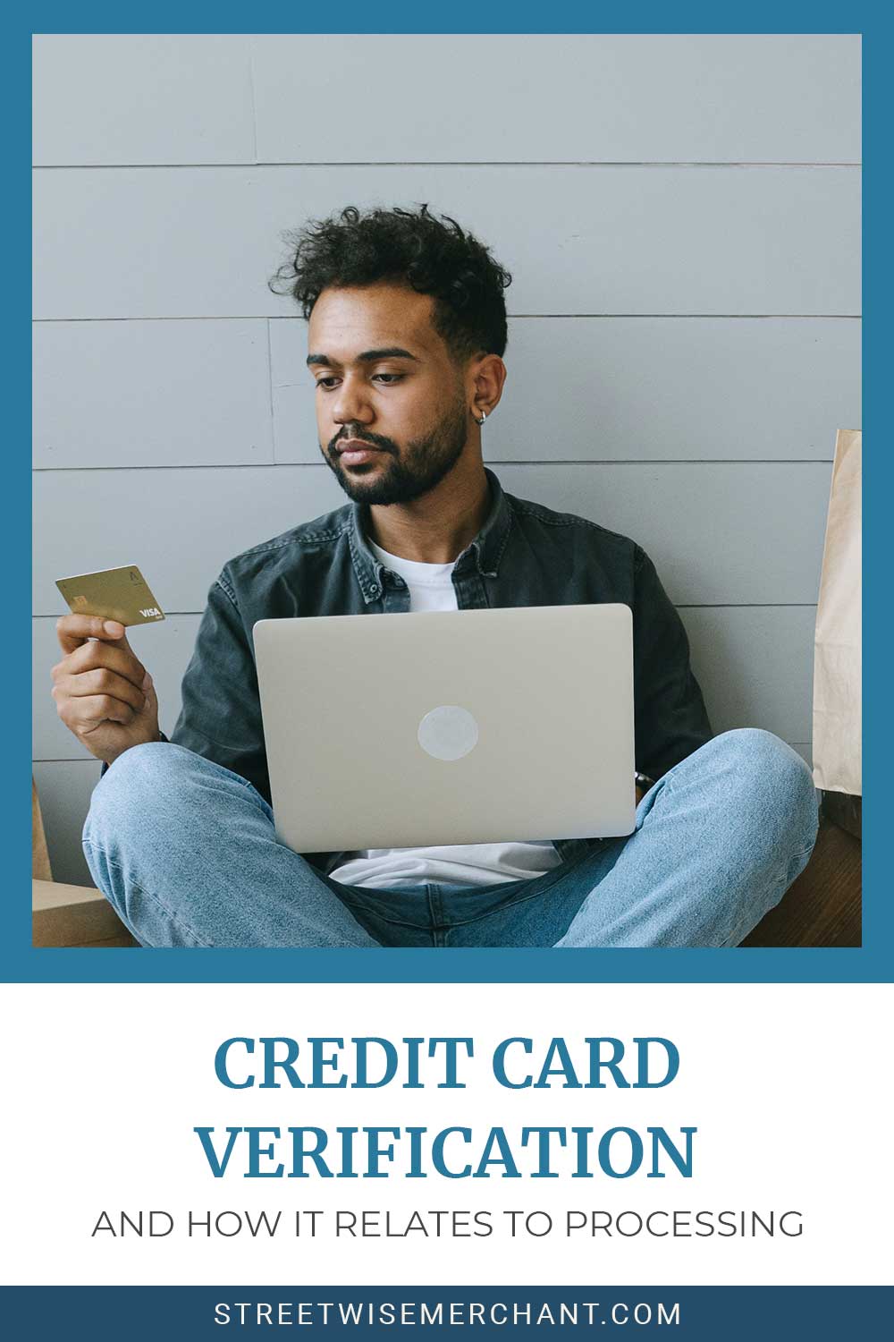 A man sitting on floor ,looking at a credit card and a laptop on his lap - Credit Card Verification and How it Relates to Processing.