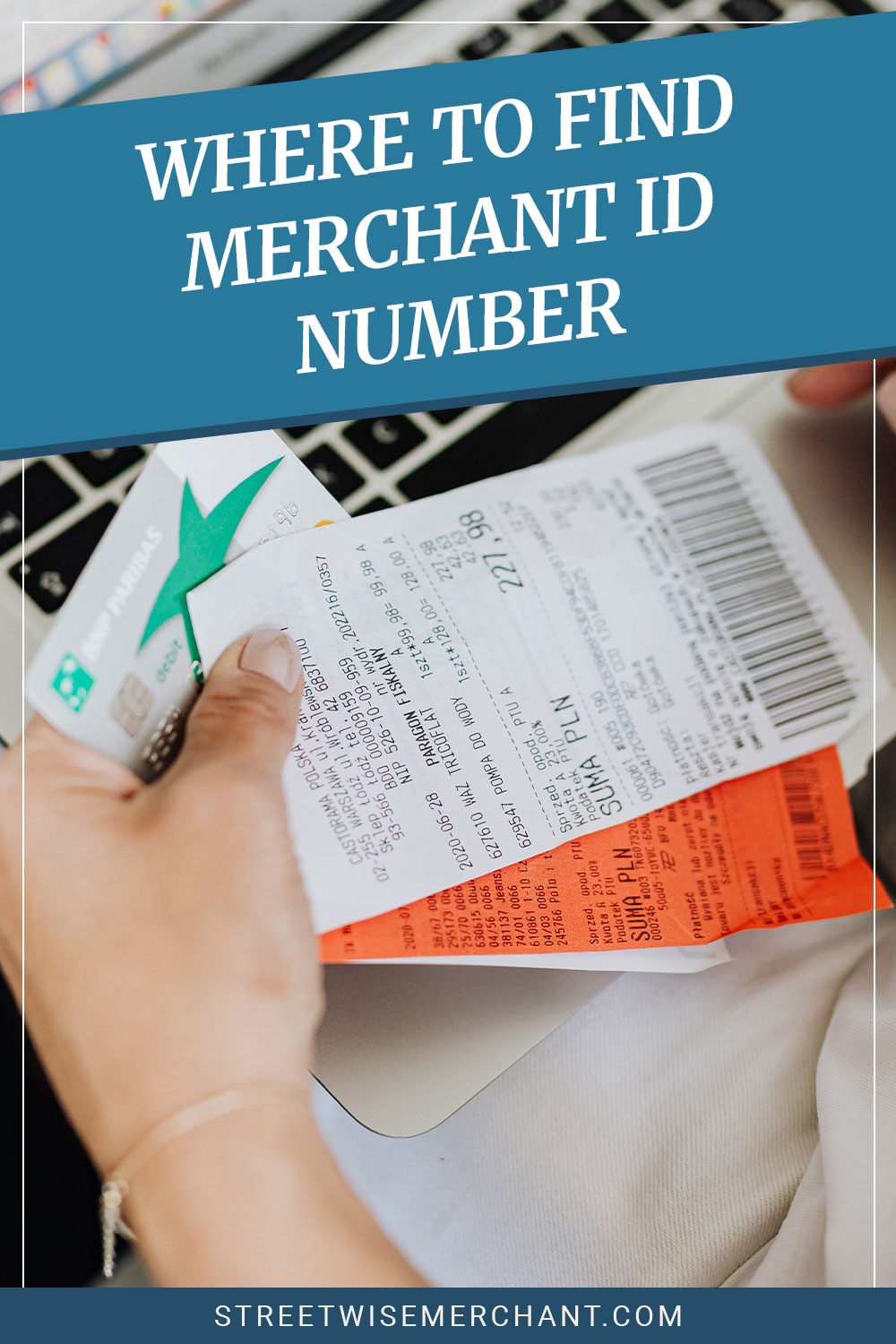 Hand holding receipt on a laptop - Where To Find Merchant Id Number